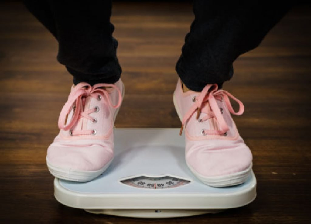 A man is checking his scale with his feet