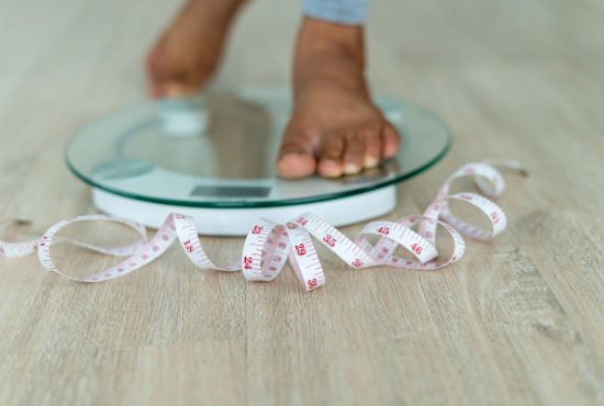 A man checking his weigh with a digital scale