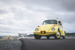 Yellow Volkswagen Beetle on Gray Sand