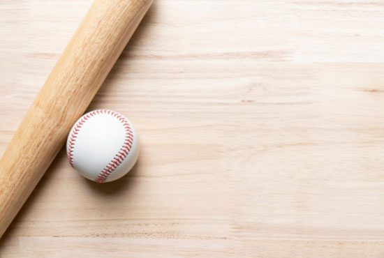 baseball and baseball bat on wooden table